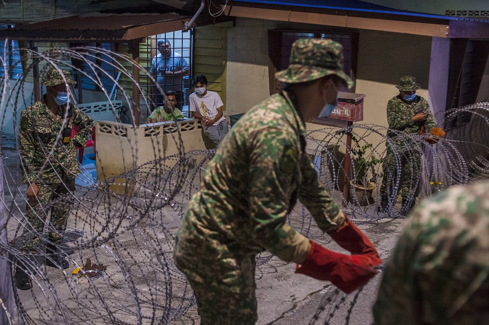 Residents look on as members of the Malaysian Armed Forces install a barbed wire fence at Kampung Segambut Dalam in Kuala Lumpur June 25, 2021. u00e2u20acu201d Picture by Shafwan Zaidon 