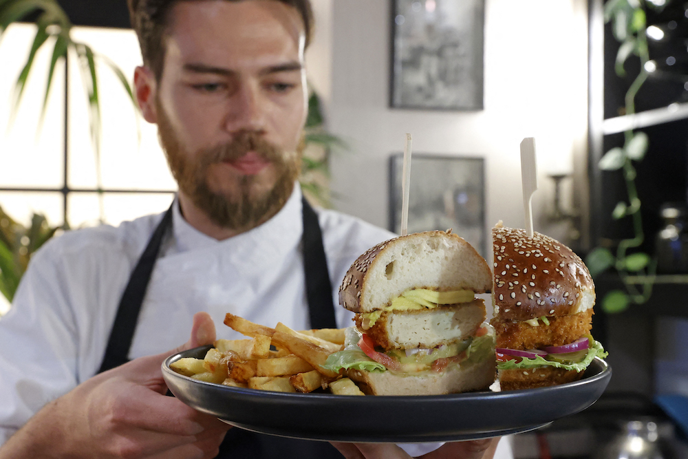 Israeli chef Shachar Yogev serves a burger made with u00e2u20acu02dccultured chickenu00e2u20acu2122 meat at a restaurant adjacent to the SuperMeat production site in the central Israeli town of Ness Ziona June 18, 2021. u00e2u20acu201d AFP pic