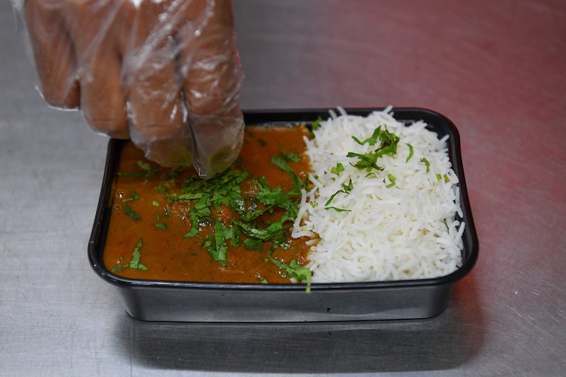 In this photograph taken on June 21, 2021, a staff garnishes a delivery order in the kitchen of the Goila Butter Chicken restaurant in Mumbai. u00e2u20acu201d AFP pic