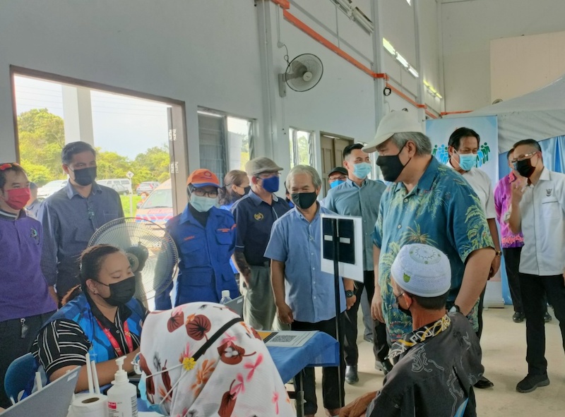 Awang Tengah (standing front, right) stops by at one of the registration counters at PPV Bisaya Culture Centre. On the Deputy Chief Ministeru00e2u20acu2122s right is Paulus. u00e2u20acu201d Borneo Post pic
