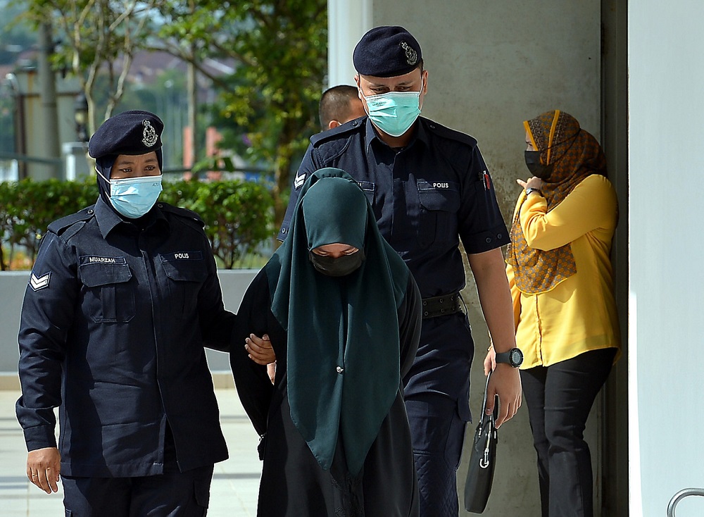 Nur Fatin Nabila Azmi (centre), 23, is led to the Sessions Court in Sepang June 21, 2021. u00e2u20acu201d Bernama pic