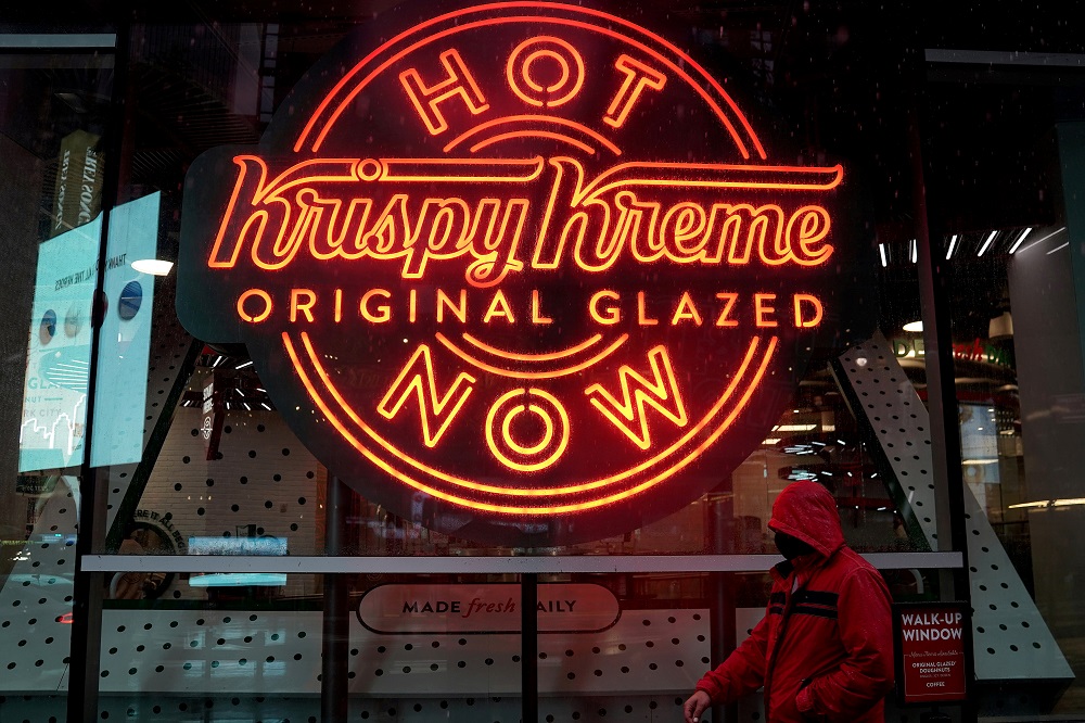 A man walks past a Krispy Kreme u00e2u20acu02dcHot Nowu00e2u20acu2122 neon sign in Times Square in the Manhattan borough of New York October 16, 2020. u00e2u20acu2022 Reuters file pic