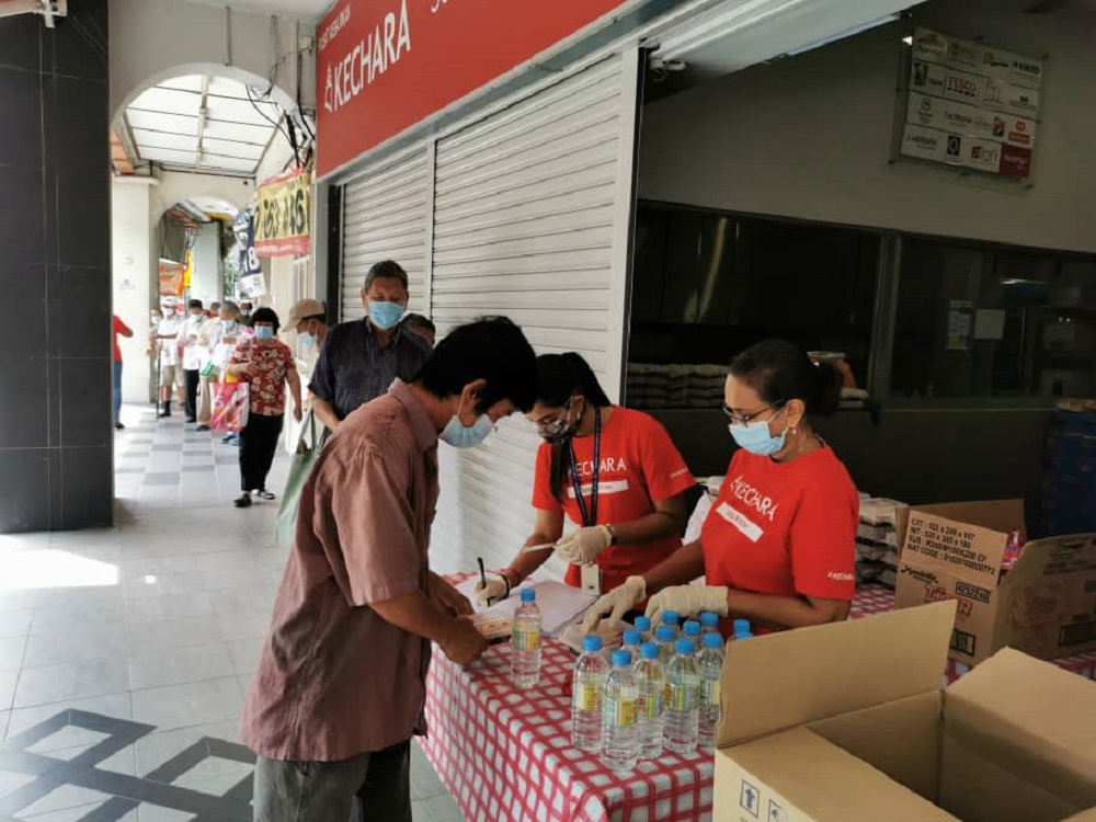 KSK volunteers packing lunch packets to be distributed to recipients in the Jalan Imbi area. ― Picture via Facebook/KecharaSoupKitchen
