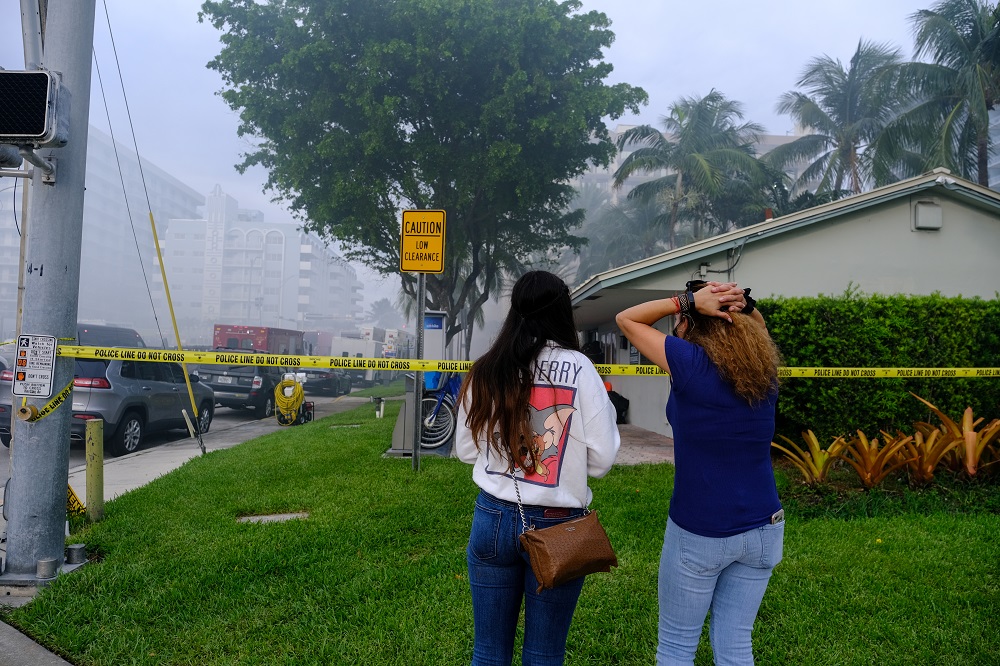 Women react as they look at the partially collapsed building in Surfside where rescue personnel continue their search for victims the day after, in Surfside near Miami Beach, Florida June 25, 2021. u00e2u20acu2022 Reuters pic