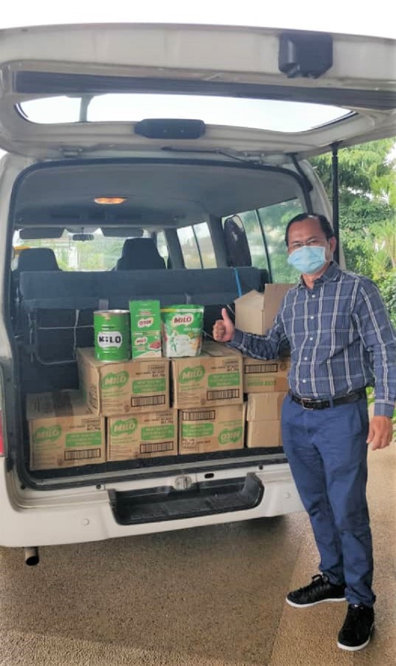 A representative of Kuching Food Aid distributes #SkuadKebaikanMILO food bundles to the local community. ― Picture courtesy of Nestle Malaysia