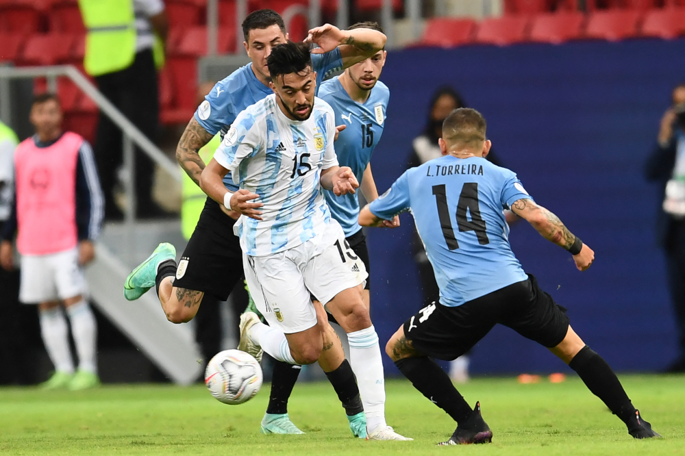 Argentinau00e2u20acu2122s Nicolas Gonzalez is challenged by Uruguayu00e2u20acu2122s Lucas Torreira during their Conmebol Copa America 2021 football tournament group phase match at the Mane Garrincha Stadium in Brasilia, June 18, 2021. u00e2u20acu201d AFP picnn