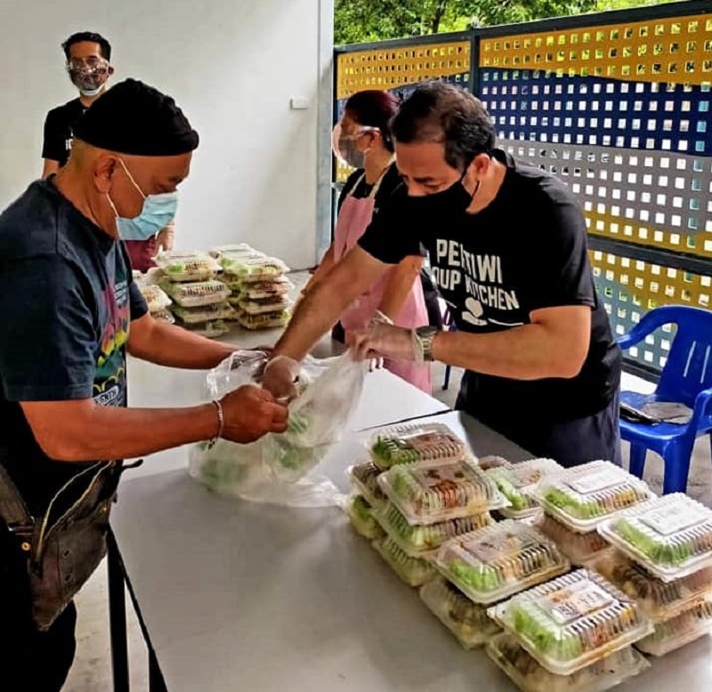 PERTIWI'S volunteers handing out food to the needy. ― Picture via Facebook/PERTIWISoupKitchen