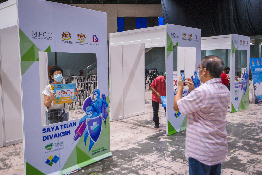People pose for pictures after their jabs at the Covid-19 vaccination centre in the Mines International Exhibition and Convention Centre, Seri Kembangan, June 17, 2021. u00e2u20acu201d Picture by Shafwan Zaidon