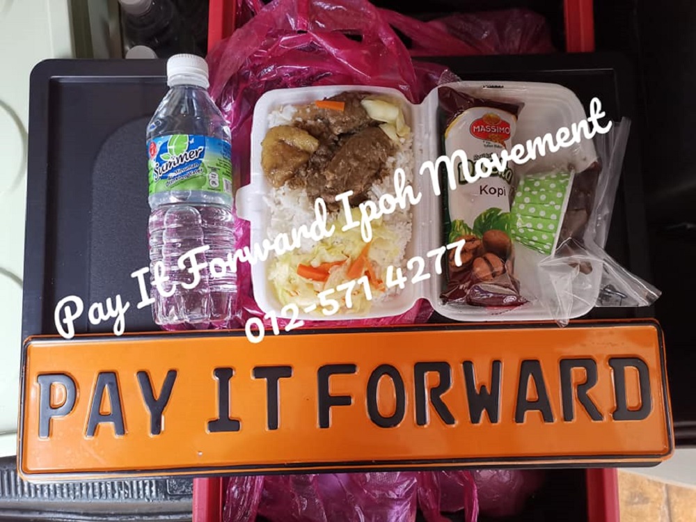 Ipoh's Pay It Forward movement usually distributes dinner packets to the poor and needy coupled with a snack and a mineral bottle. ― Picture via Facebook/PayItForwardIpohMovement-PIFI