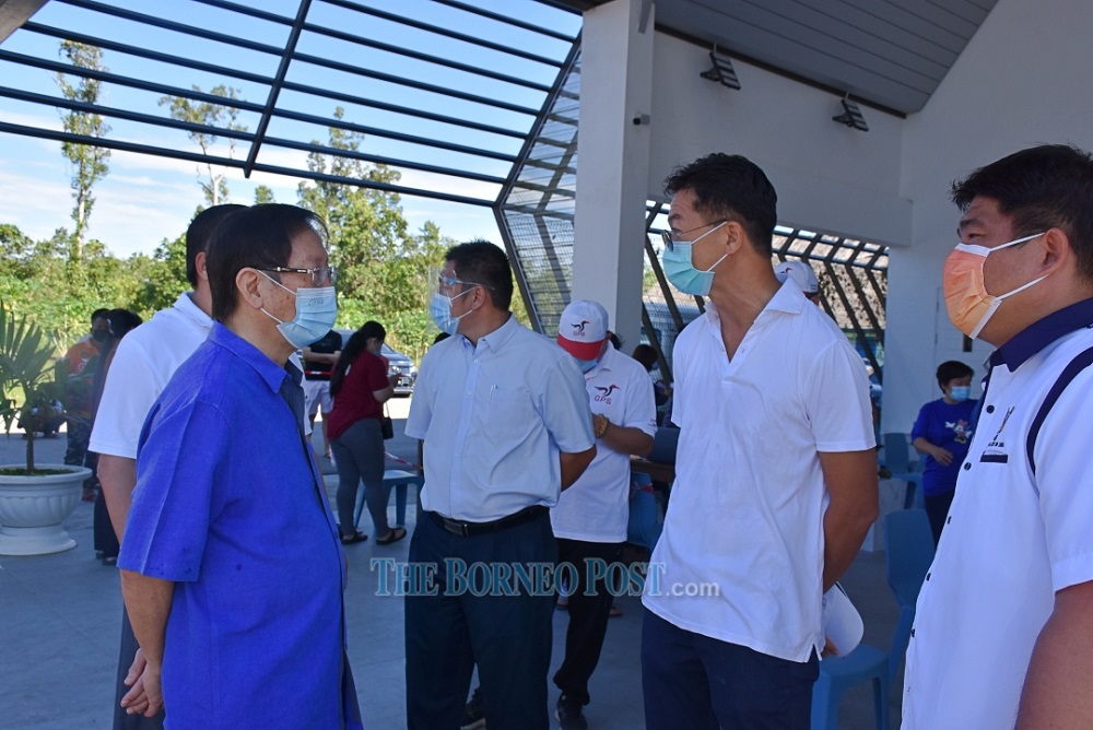 Vincent Lau (left) chatting with Senator Robert Lau (second right) at the SJK Kwong Hua PPV. u00e2u20acu201d Borneo Post Online pic
