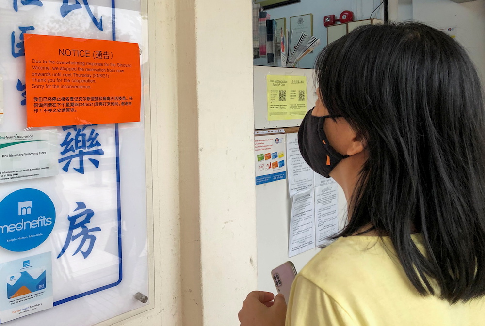 A woman reads a notice sign about u00e2u20acu02dcoverwhelming responseu00e2u20acu2122 for the Sinovac vaccine at a clinic, during the coronavirus disease outbreak in Singapore June 18, 2021. u00e2u20acu201d Reuters picnnnnn