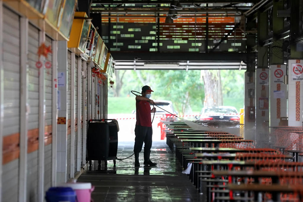 A cleaning worker washing the tables at 115 Bukit Merah View Market and Food Centre on June 14, 2021. u00e2u20acu2022 TODAY pic