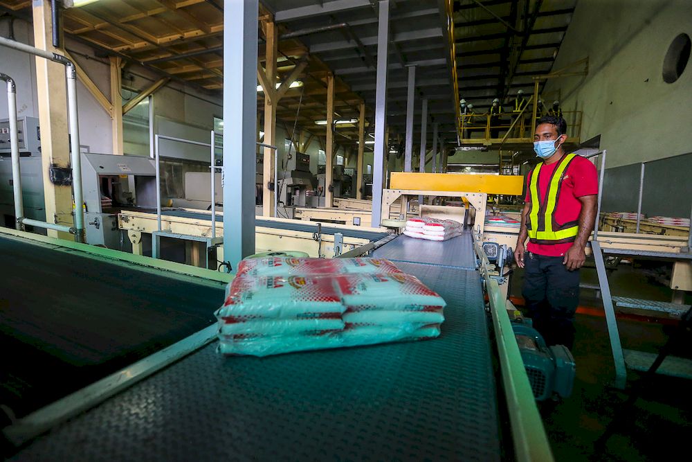 A worker arranges packets of sugar on the production line at Central Sugar Refinery Sdn. Bhd (CSR) in Shah Alam, June 22, 2021. u00e2u20acu201d Picture by Yusof Mat Isa