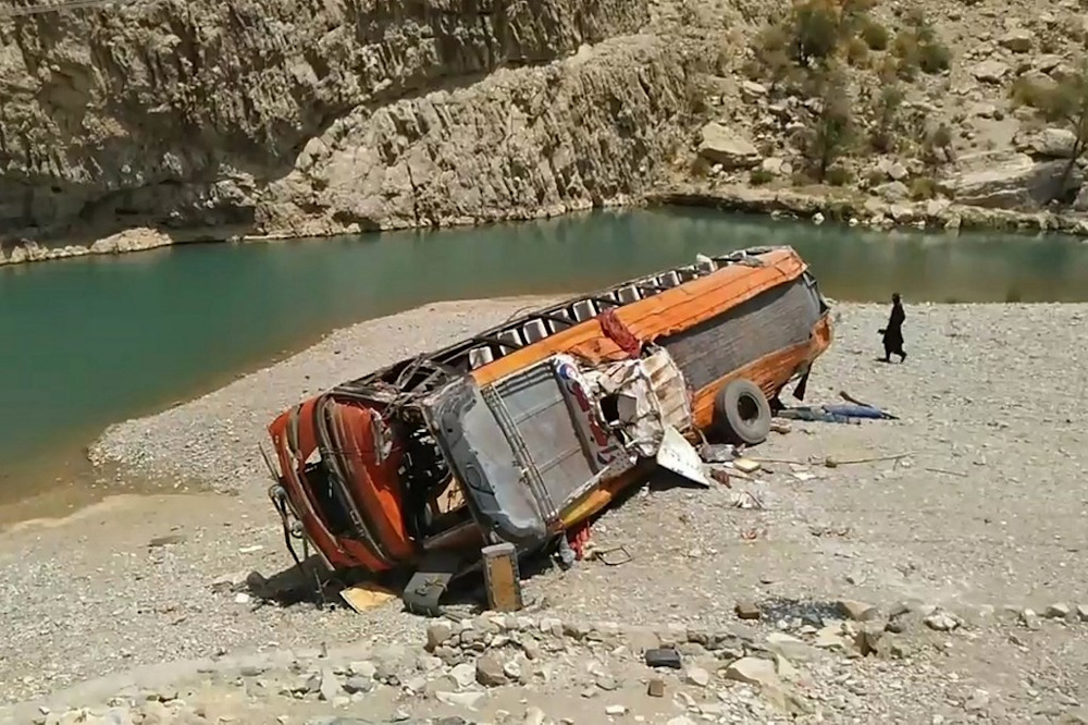 A man walks past a damaged bus at the site of an accident in a remote district of Balochistan province on June 11, 2021. u00e2u20acu201d AFP pic