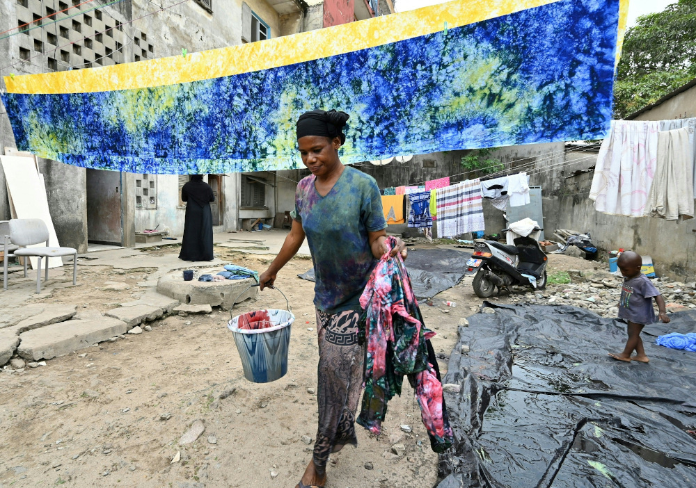 Dyers dye cotton fabric at Patheu00e2u20acu2122O house in the popular district of Treichville in Abidjan. u00e2u20acu201d AFP pic