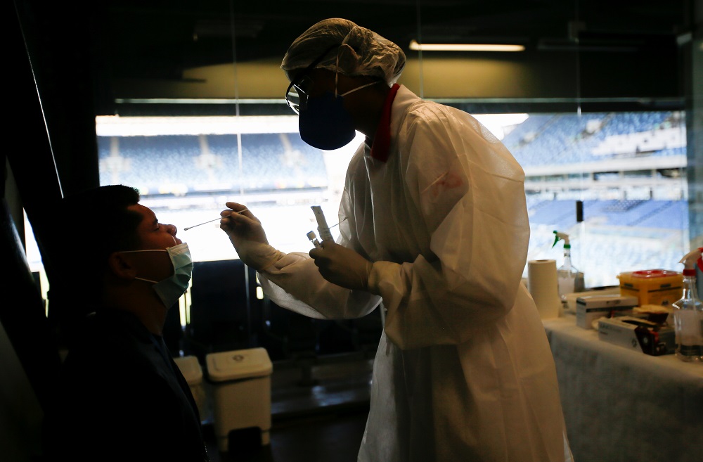 A health care worker performs a PCR test for Covid-19 to a worker of Arena Pantanal in Cuiaba, Brazil June 22, 2021. u00e2u20acu2022 Reuters pic