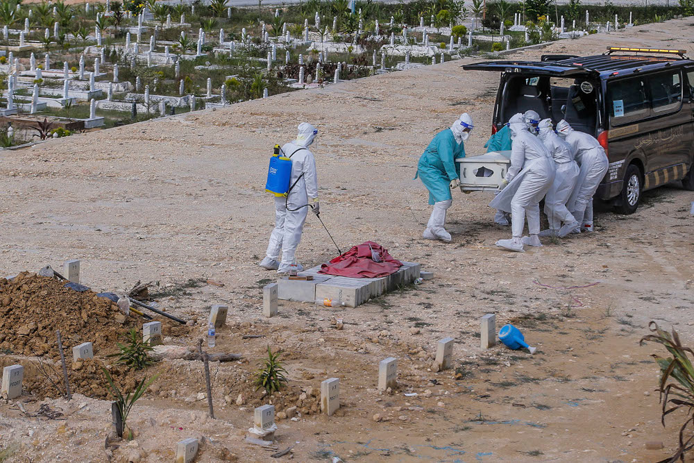 Workers in personal protective equipment prepare to bury the body of a Covid-19 victim at the Muslim cemetery in Gombak June 8, 2021. u00e2u20acu2022 Picture by Hari Anggara