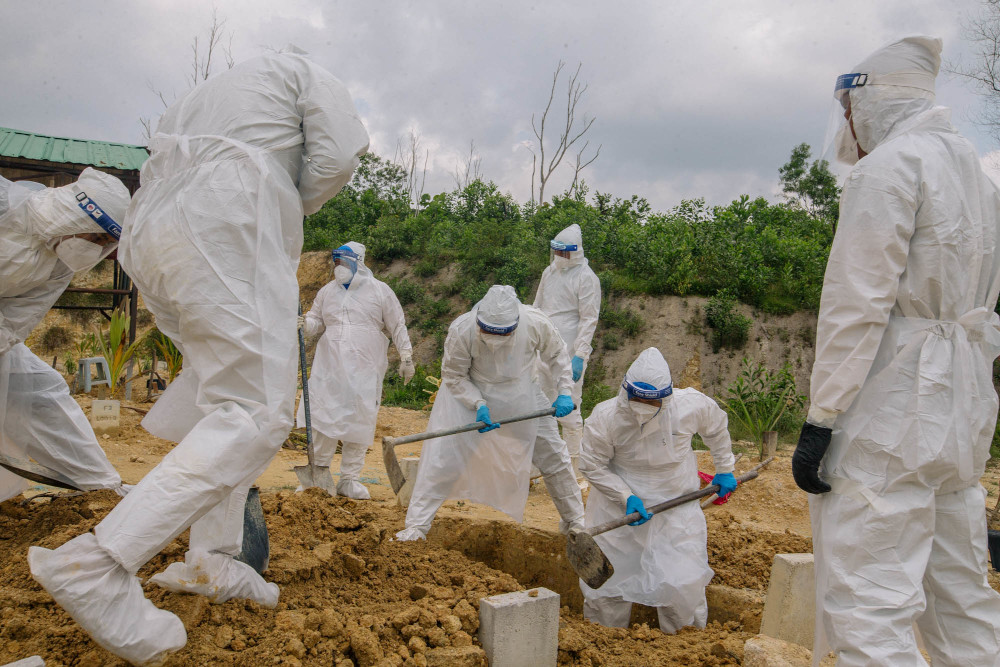 Health workers wearing personal protective equipment bury a person who died from Covid-19 at the Muslim cemetery in Gombak June 6, 2021. — Picture by Firdaus Latif