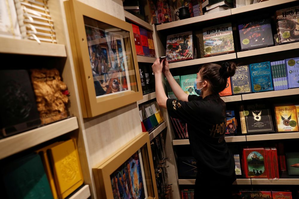 An employee of the Harry Potter New York store pulls a book from a shelf during press preview in the Flatiron district of New York City May 28, 2021. u00e2u20acu201d Reuters pic