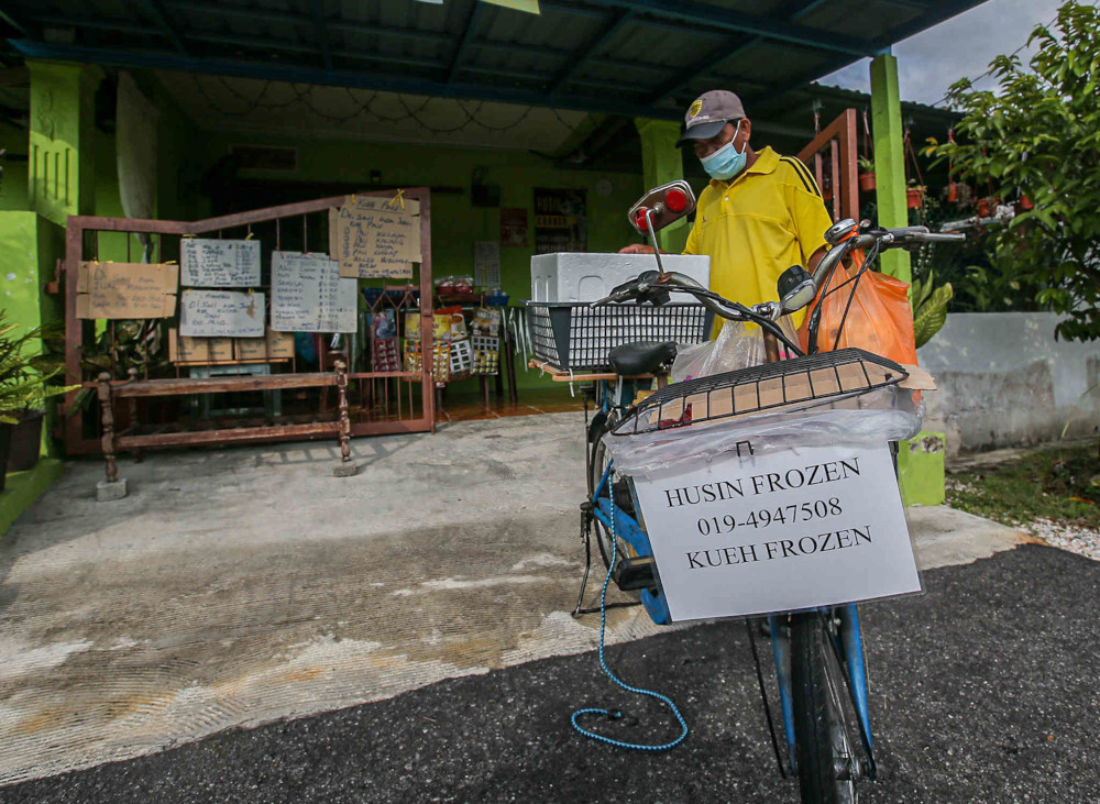 The movement control order (MCO) did not stop elderly citizen Husin Muhamad, 60, from selling frozen food via his bicycle around Kampung Tengku Hussein Hujong, Manjoi in Ipoh. u00e2u20acu201d Picture by Farhan Najib