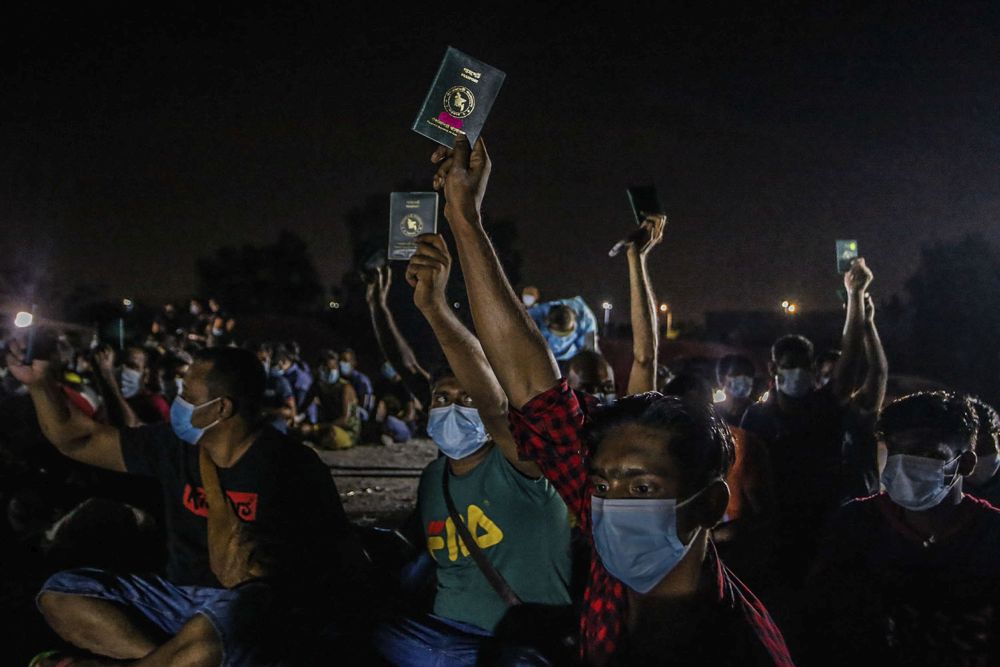 Foreign workers hold up their documentations during a raid on a construction site by the Immigration Department in Cyberjaya June 6, 2021. u00e2u20acu201d Picture by Hari Anggara