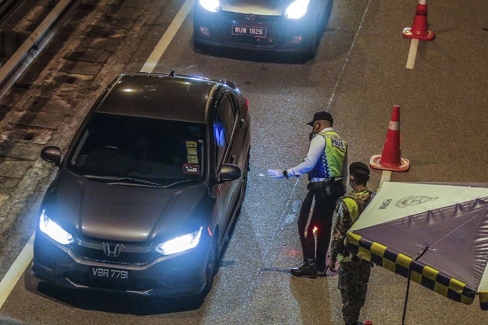 Police and Armed Forces personnel conduct checks on vehicles at a roadblock at Jalan Ipoh-Rawang June 1, 2021. u00e2u20acu201d Picture by Hari Anggarann