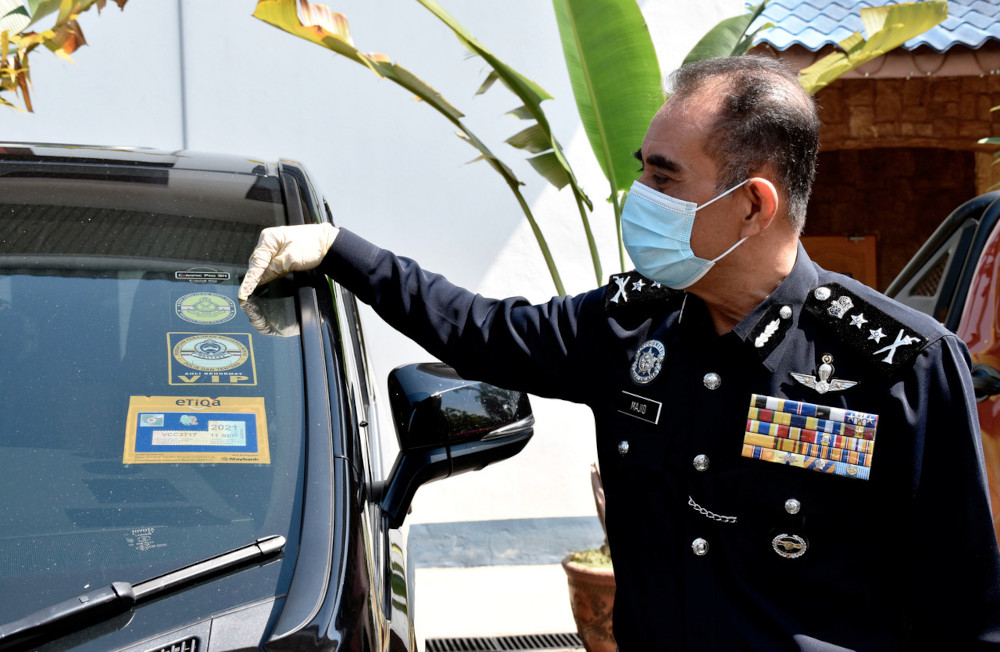 Melaka police chief Datuk Abdul Majid Mohd Ali showing the car stickers resembling the Royal Malaysia Police logo used on a vehicle by Gang 36 members at a press conference in Melaka, June 11, 2021. u00e2u20acu201d Bernama pic 