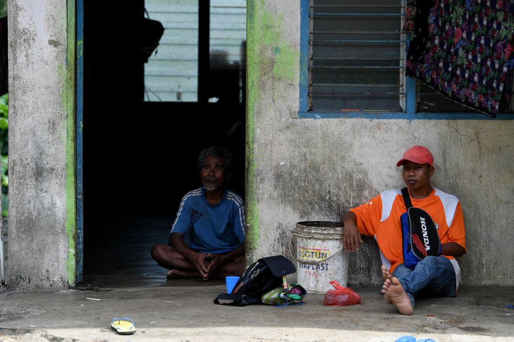 An elderly Semaq Beri Orang Asli and his son at home during the movement control order at the Sungai Berua Orang Asli village in Terengganu, June 8, 2021. u00e2u20acu201d Bernama pic  