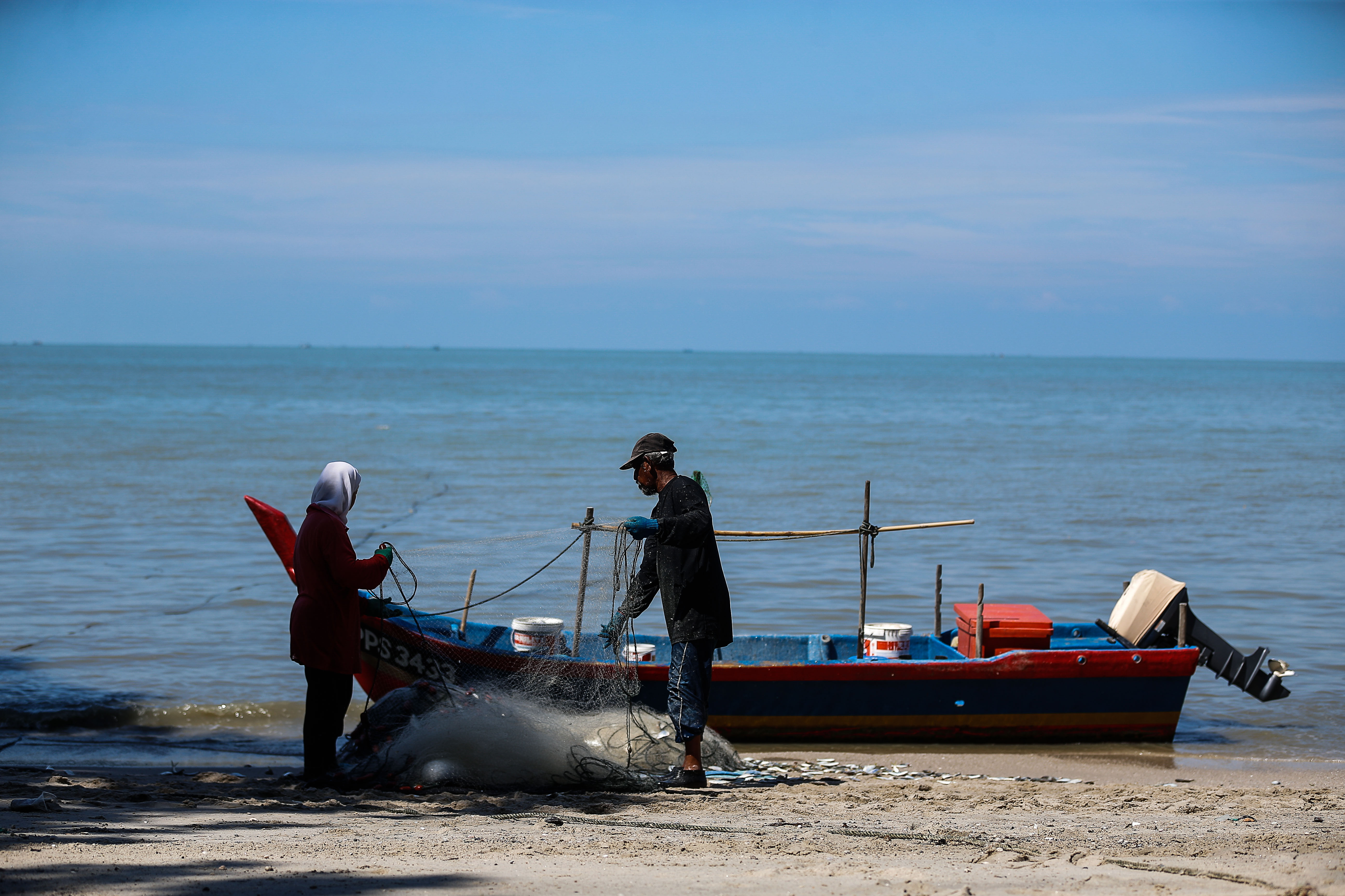 nFishermen are pictured mending their nets at Bayan Lepas June 16, 2021. u00e2u20acu201d Picture by Sayuti Zainudinn