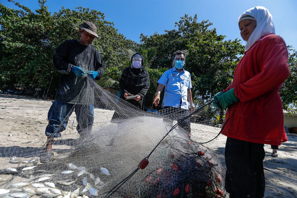Deputy Agriculture and Food Industry Minister II Datuk Che Abdullah Mat Nawi (second from right) speaks to fisherfolk during a visit to Bayan Lepas June 16, 2021. u00e2u20acu201d Picture by Sayuti Zainudinnn