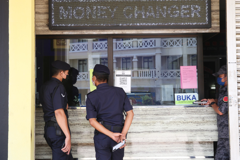 Enforcement officers (Police, Immigration and Army) checking the standard operating procedure (SOP) compliance at shops in Putrajaya, June 14, 2021. u00e2u20acu201d Picture by Choo Choy May 