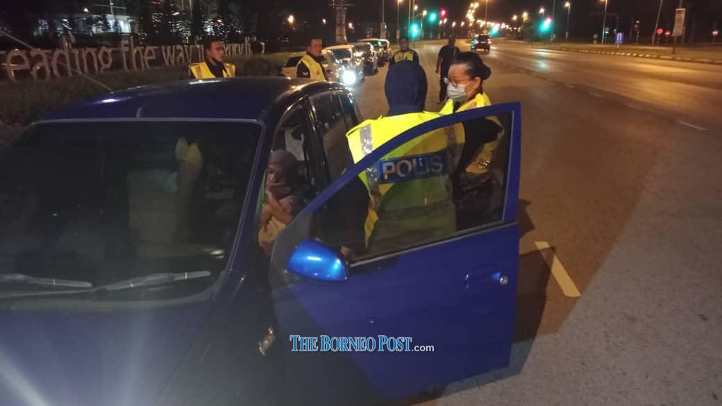 The policewomen check on the mother and baby in the car. u00e2u20acu2022 Borneo Post pic