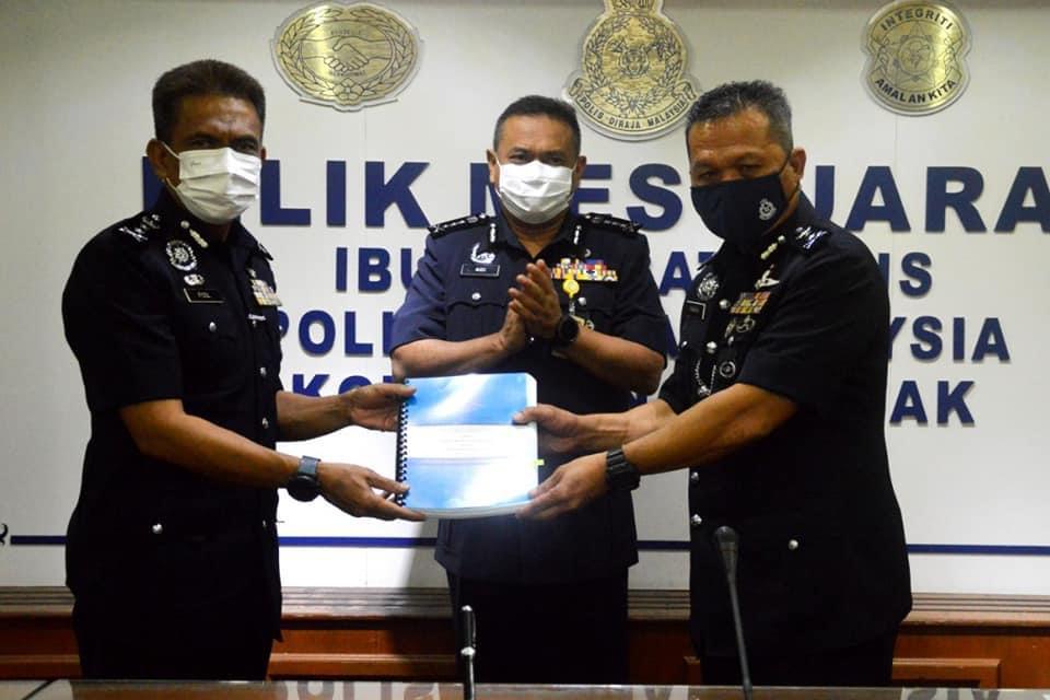 DCP Mancha Ata (right) exchanging documents with Fisol during the ceremony, witnessed by Sarawak Police Commissioner Datuk Aidi Ismail (centre). u00e2u20acu2022 Borneo Post pic