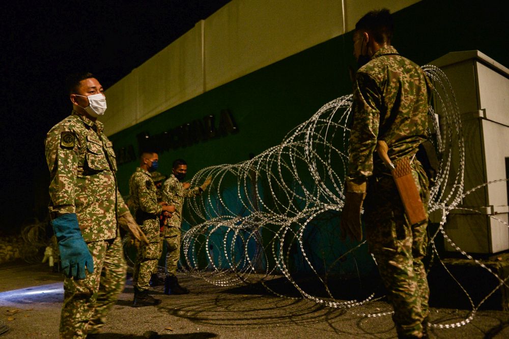 Armed Forces personnel install barbed wire fencing in Kampung Sungai Penchala as the enhanced movement control order kicks in today June 10, 2021. u00e2u20acu201d Picture by Miera Zulyana