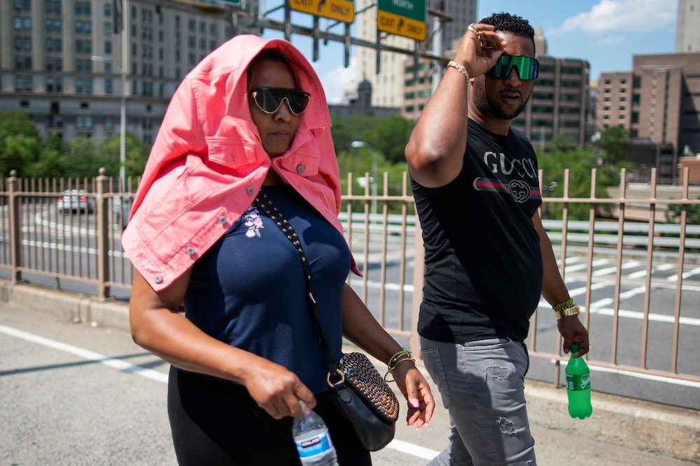 A woman covering herself from the sun walks during a heat wave at the Brooklyn Bridge in New York June 30, 2021. u00e2u20acu201d Reuters pic