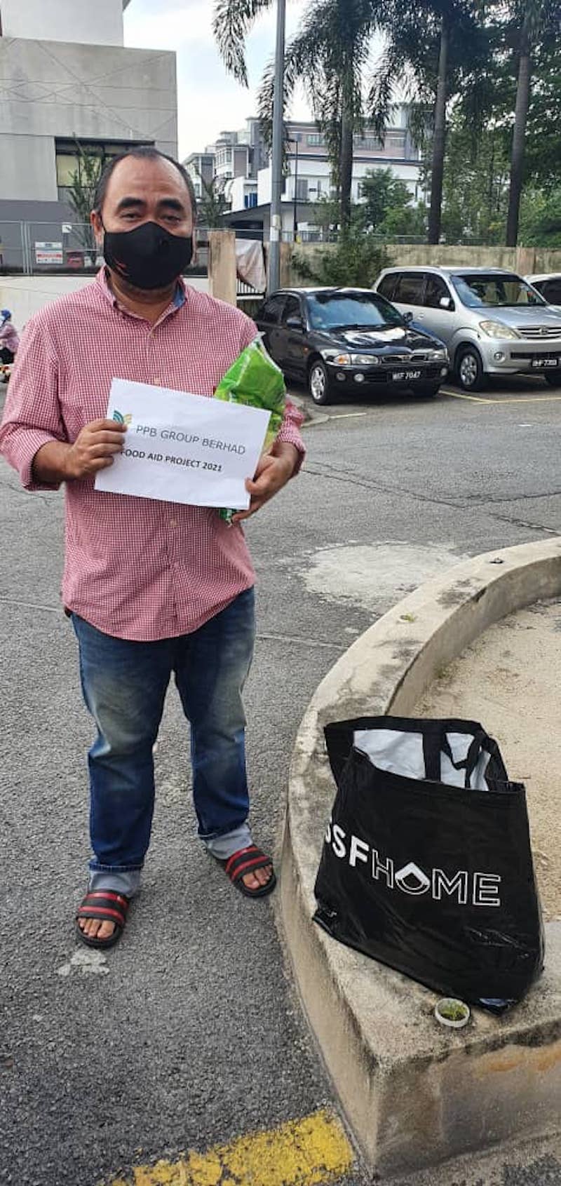 Mohd Rizly receiving the food packet from Persatuan Pemuzik Malaysia last month to help him with his household expenditure. — Picture courtesy of Persatuan Pemuzik Malaysia