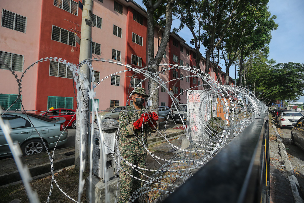 Armed Forces personnel install barbed wire fencing at Pangsapuri Bandar Bukit Tinggi 1, Jalan Nilam 15 during the enhanced movement control order (EMCO) in Klang July 18, 2021. u00e2u20acu201d Picture by Yusof Mat Isa