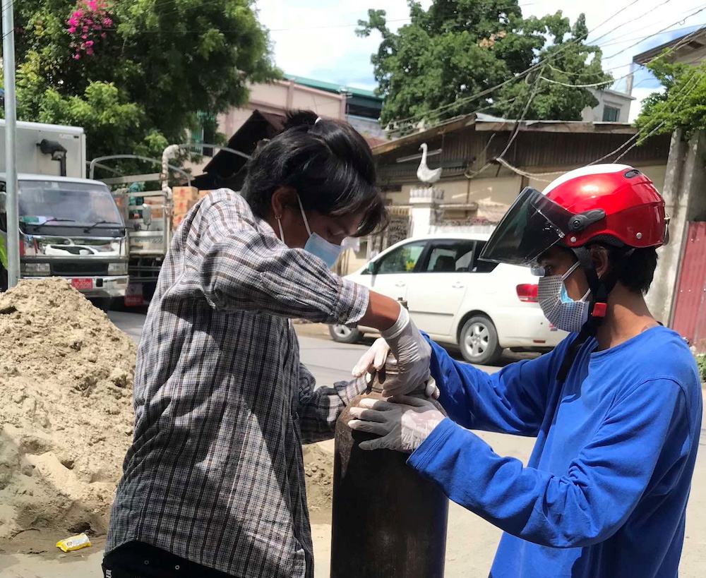 A volunteer fills an oxygen tank as Covid-19 cases surge in Mandalay, Myanmar July 13, 2021. u00e2u20acu201d Phoe Thar via Reuters