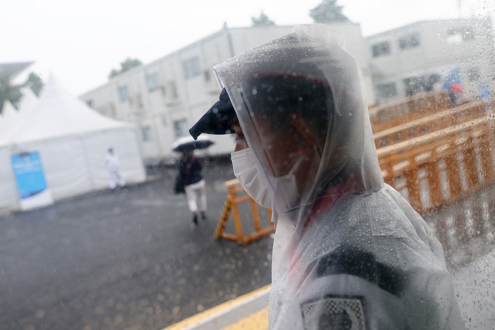 A security man stands guard at the door of Tokyo Aquatics Centre as tropical storm Nepartak approaches Tokyo July 27, 2021. u00e2u20acu201d Reuters pic