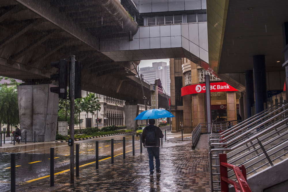 Pedestrians walking on the sidewalk while holding umbrellas in Kuala Lumpur July 10, 2021. u00e2u20acu201d Picture by Shafwan Zaidon