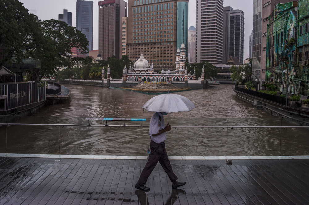 Pedestrians walking on the sidewalk while holding umbrellas in Kuala Lumpur July 10, 2021. u00e2u20acu201d Picture by Shafwan Zaidon