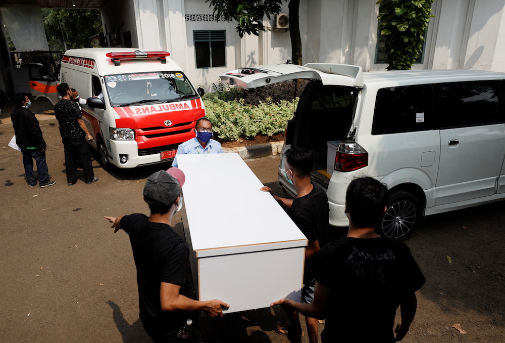 Workers wearing protective masks load empty coffins for coronavirus disease (Covid-19) victims into an ambulance to be distributed to a hospital as the cases surge in Jakarta, Indonesia, July 5, 2021. u00e2u20acu201d Reuters pic