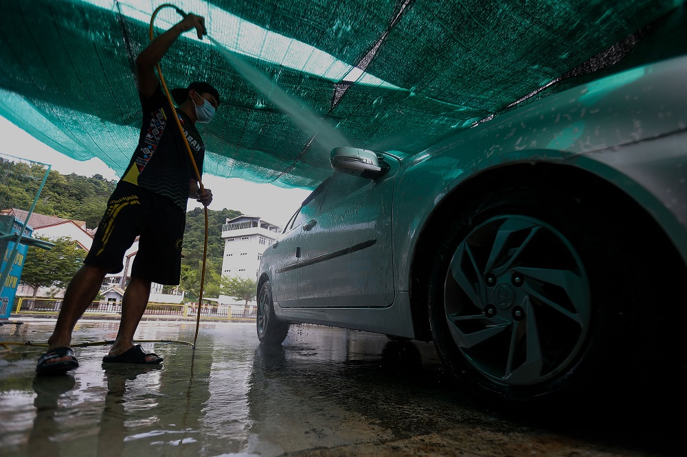 A staff cleans a vehicle at the Rainforest Car Care Centre in George Town July 7, 2021. -— Picture by Sayuti Zainudin