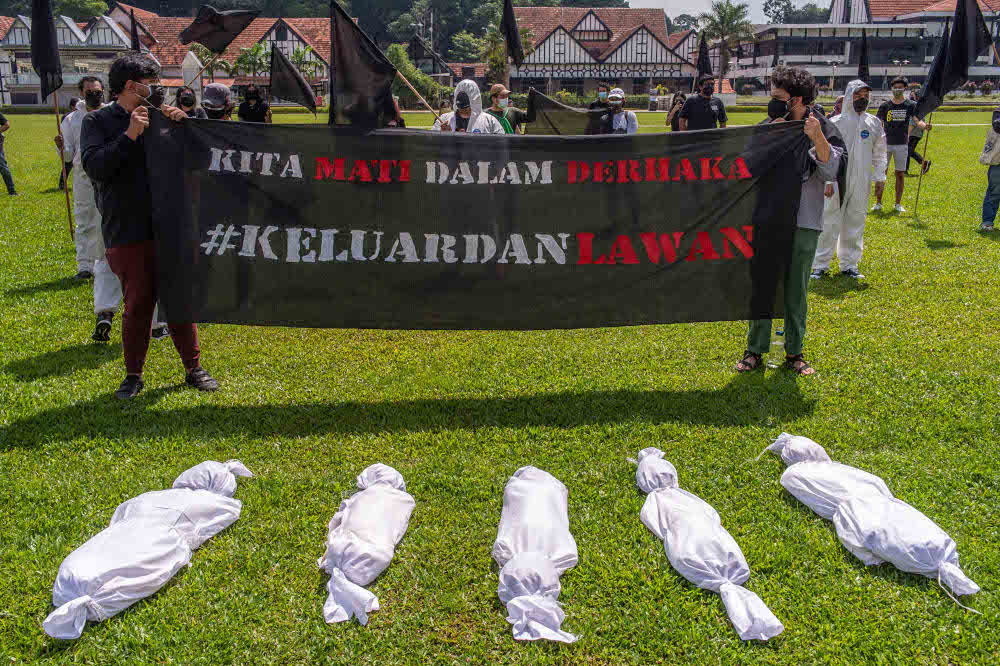 Protesters wearing personal protective equipment (PPE) holding banners and effigies of corpses during the Black Flag protest demanding the resignation of prime minister Tan Sri Muhyiddin Yassin. u00e2u20acu201d Picture by Shafwan Zaidon