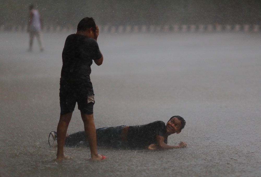 Children play on a flooded street after heavy rains in New Delhi, India, July 14, 2021. u00e2u20acu201d Reuters pic
