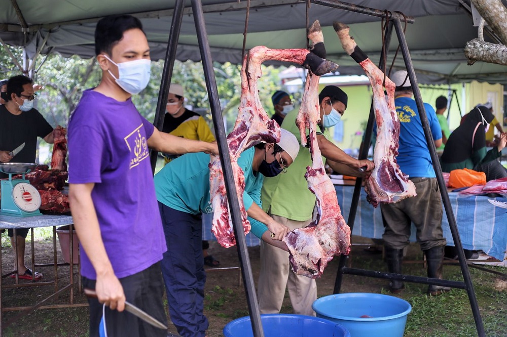 Members of the public adhere to Covid-19 SOPs as they take part in the ritual slaughter of a cow during Hari Raya Aidiladha at the Kota Damansara mosque in Petaling Jaya July 20, 2021. — Picture by Ahmad Zamzahuri