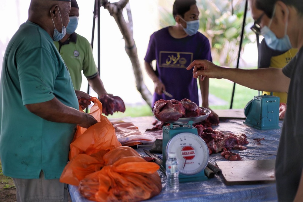 Members of the public adhere to Covid-19 SOPs as they distribute meat following the ritual slaughter of a cow during Hari Raya Aidiladha at the Kota Damansara mosque in Petaling Jaya July 20, 2021. u00e2u20acu201d Picture by Ahmad Zamzahuri