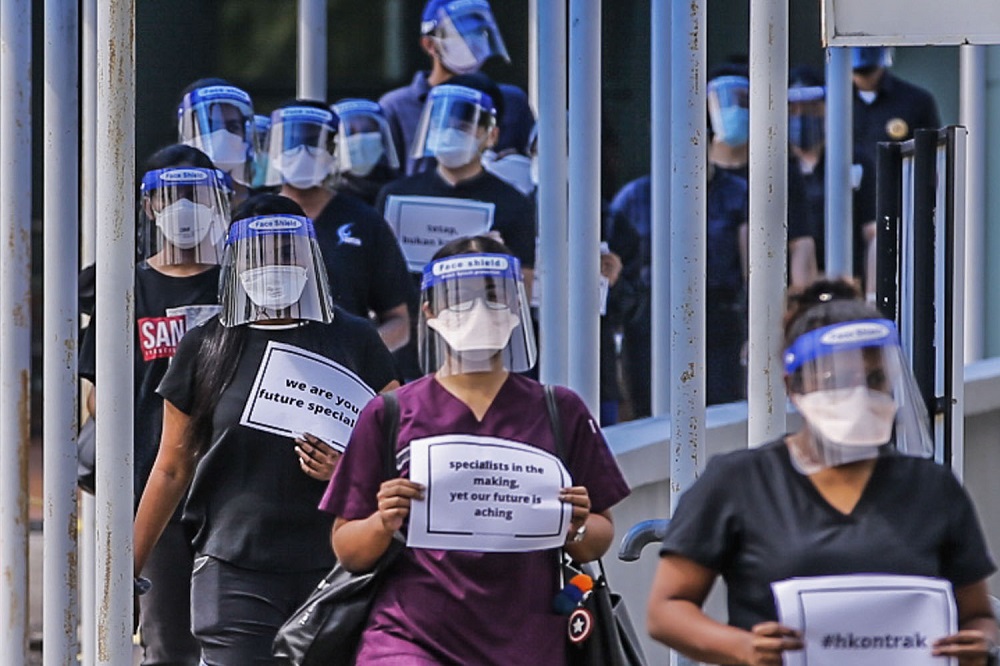 Contract doctors hold aloft placards demanding equal treatment as they go on strike at the Sungai Buloh Hospital July 26, 2021. u00e2u20acu201d Picture by Hari Anggara 