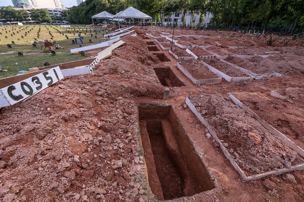 Graves are dug in advance before the bodies arrive at the Raudhatul Sakinah Bukit Kiara 1 Muslim cemetery for burial. 