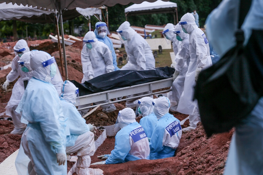 Civil Defence Force members in full personnel protective equipment perform the burial service in Raudhatul Sakinah Bukit Kiara 1 Muslim cemetery. 